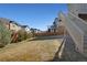 Spacious fenced backyard features a sloped lawn and stairs leading to an elevated deck at 24317 E Powers Ave, Aurora, CO 80016