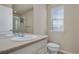 Well-lit bathroom featuring a large mirror, sink, toilet, and shower with glass door at 24317 E Powers Ave, Aurora, CO 80016