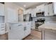 Modern kitchen features white cabinetry, stainless steel appliances, and a stylish kitchen island at 24317 E Powers Ave, Aurora, CO 80016