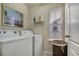 Clean laundry room with modern washer and dryer, shelving, and a window with blinds at 24317 E Powers Ave, Aurora, CO 80016