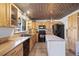Bright kitchen with wood cabinets, black appliances, tile floors, and unique metal-patterned ceiling at 10826 Livingston Dr, Northglenn, CO 80234