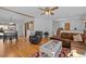 Open-concept living room featuring hardwood floors, a comfortable seating area, and seamless access to the dining area at 10826 Livingston Dr, Northglenn, CO 80234