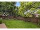 Green backyard with a wooden fence, mature trees, and a swing set at 2249 Weatherstone Cir, Highlands Ranch, CO 80126