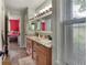 Bathroom with dual sinks, wood cabinets, granite countertop, and natural light from the window at 2249 Weatherstone Cir, Highlands Ranch, CO 80126