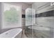 Modern bathroom features a soaking tub, glass-enclosed shower and a large window at 2249 Weatherstone Cir, Highlands Ranch, CO 80126