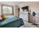 Comfortable bedroom with dresser, tv, and bright natural light from the window at 2249 Weatherstone Cir, Highlands Ranch, CO 80126