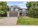 Charming two-story home with stone accents, gray siding, manicured lawn and two car garage at 2249 Weatherstone Cir, Highlands Ranch, CO 80126