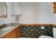 Cozy half-bathroom with granite countertop, wood cabinets, and unique floral wallpaper design at 7871 Ogden Ct, Denver, CO 80229