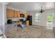 Bright kitchen featuring tile floors, wooden cabinets, black appliances, and granite countertops at 7871 Ogden Ct, Denver, CO 80229