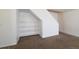 Living room featuring carpet flooring and a built-in bookshelf next to the staircase at 7871 Ogden Ct, Denver, CO 80229