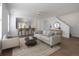 Bright living room featuring a gray sofa, accent chair, round coffee table, and pass-through to the kitchen at 7871 Ogden Ct, Denver, CO 80229