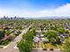 Wide aerial view of a green neighborhood with a cityscape backdrop and tree-lined streets at 3015 N Fillmore St, Denver, CO 80205
