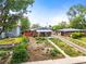 Charming bungalow with xeriscaped front yard and cozy covered porch with vibrant yellow and green chairs at 3015 N Fillmore St, Denver, CO 80205