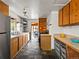 Bright kitchen featuring stone floors, wooden cabinets, and stainless steel appliances at 3015 N Fillmore St, Denver, CO 80205
