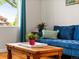 Comfortable living room featuring a plush blue sofa and bright accents, illuminated by natural light at 3015 N Fillmore St, Denver, CO 80205