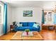 Inviting living room featuring a plush blue sofa with hardwood floors, decorated with green and blue throw pillows at 3015 N Fillmore St, Denver, CO 80205