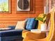 Seating area with plush blue chaise, a yellow chair, and wood paneling at 3015 N Fillmore St, Denver, CO 80205