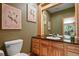 Charming bathroom with a wooden vanity, framed mirror, and warm lighting for a relaxing atmosphere at 6398 Lost Canyon Ranch Rd, Castle Rock, CO 80104