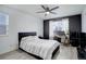 Comfortable bedroom featuring a dark accent wall, a ceiling fan, and a work space at 11821 W Independence Ave, Lakewood, CO 80401