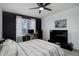 Relaxing bedroom features a dark accent wall, a ceiling fan, and an entertainment area at 11821 W Independence Ave, Lakewood, CO 80401