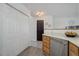 View of kitchen area with updated countertops, stainless steel dishwasher, and pantry closet for storage at 11821 W Independence Ave, Lakewood, CO 80401