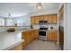 Well-lit kitchen features stainless steel appliances, light wood cabinets, and updated countertops and flooring at 11821 W Independence Ave, Lakewood, CO 80401