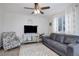 Comfortable living room featuring a large sofa, ceiling fan, and natural light at 11821 W Independence Ave, Lakewood, CO 80401