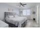Bedroom with a plush bed, ceiling fan, neutral walls, and updated flooring provides a relaxing retreat at 11821 W Independence Ave, Lakewood, CO 80401