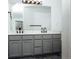 Bathroom with double vanity, grey cabinets, large mirror, and modern fixtures at 18656 E Harvard Dr, Aurora, CO 80013