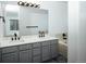 Bathroom with double vanity, grey cabinets, large mirror, and soaking tub at 18656 E Harvard Dr, Aurora, CO 80013