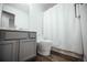 A modern bathroom featuring gray vanity, a white toilet, and shower with curtain at 18656 E Harvard Dr, Aurora, CO 80013