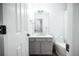 A modern bathroom featuring gray vanity, a white toilet, and a large mirror at 18656 E Harvard Dr, Aurora, CO 80013