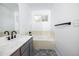 Bathroom featuring a white tub, gray vanity, and plenty of natural light from the window at 18656 E Harvard Dr, Aurora, CO 80013