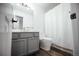 A modern bathroom featuring gray vanity, a white toilet, and shower with curtain at 18656 E Harvard Dr, Aurora, CO 80013