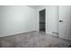 View of a bedroom with gray carpet, a white door, and a closet with shelving at 18656 E Harvard Dr, Aurora, CO 80013