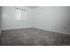 A comfortable bedroom featuring soft gray carpeting and a bright window at 18656 E Harvard Dr, Aurora, CO 80013