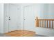 Hallway with hardwood floors, complemented by white doors and staircase at 18656 E Harvard Dr, Aurora, CO 80013