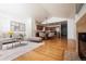 Open-concept living room featuring hardwood floors, fireplace, dining area, and an adjacent kitchen at 18656 E Harvard Dr, Aurora, CO 80013