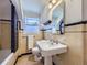 Charming bathroom featuring a pedestal sink, classic tiling, and a window for natural light at 2540 Forest St, Denver, CO 80207