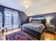 Primary bedroom with dark blue walls, rug, hardwood floors, and french doors to a balcony for added charm at 2540 Forest St, Denver, CO 80207