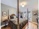 Cozy bedroom featuring a four-poster bed with a luxurious, patterned quilt and French doors to a balcony at 2540 Forest St, Denver, CO 80207