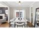 Bright dining room with a wooden table, white chairs, and a view into kitchen at 1460 S Emerson St, Denver, CO 80210