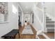 Bright entryway with hardwood floors, bench, and staircase leading upstairs at 1460 S Emerson St, Denver, CO 80210