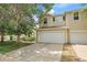 Charming townhome with a two-car garage and a driveway with mature trees and shrubs at 7977 S Kittredge St, Englewood, CO 80112