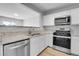 Bright kitchen with white cabinetry, stainless steel appliances, and granite countertops at 7977 S Kittredge St, Englewood, CO 80112