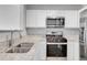 Bright kitchen with white cabinetry, stainless steel appliances, and granite countertops at 7977 S Kittredge St, Englewood, CO 80112