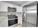 Modern kitchen features stainless steel appliances, white cabinets and granite countertops at 7977 S Kittredge St, Englewood, CO 80112