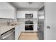 Well-equipped kitchen with stainless steel appliances, granite countertops, and white cabinets at 7977 S Kittredge St, Englewood, CO 80112