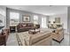 Bright living room featuring a brown leather sofa, decorative rug, and a dining area with seating for six at 7977 S Kittredge St, Englewood, CO 80112