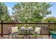 Cozy deck with wood railing and table set up for dining, surrounded by lush trees and greenery at 7158 Torrey St, Arvada, CO 80007